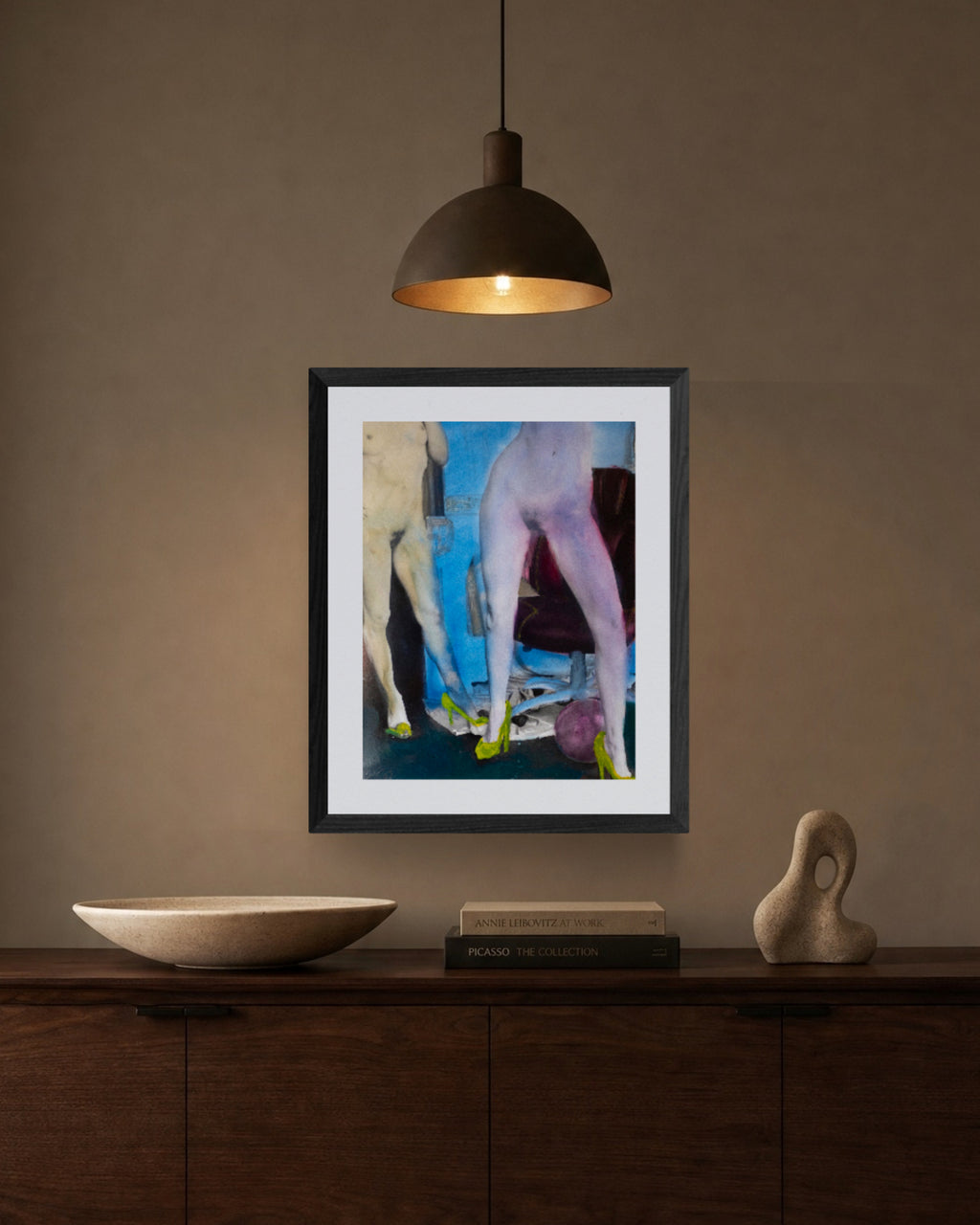 Framed hand-painted silver gelatin print on a wall above a wooden console table with decorative items.